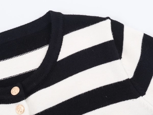 Detailed view of striped knit cardigan featuring embossed gold anchor buttons