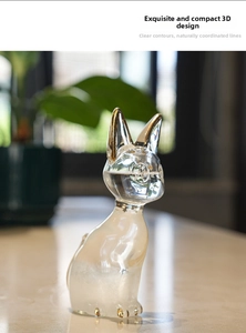 Close-up of glass Bastet storm bottle with gold accents and clear crystalline texture