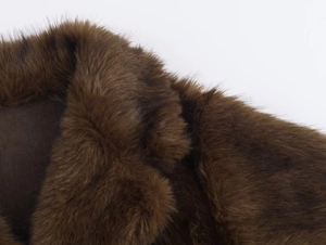 Gros plan du col en fourrure synthétique marron foncé montrant la texture douce et épaisse