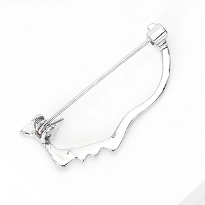 Detailed view of an abstract silver metal face brooch with a sleek polished finish