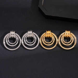 Macro detail of geometric hollow round layered hoop earrings in gold and silver finish