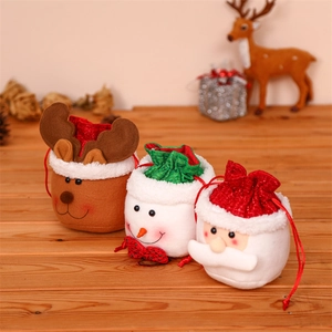 Close-up of Christmas drawstring gift bags featuring plush reindeer, snowman, and Santa designs
