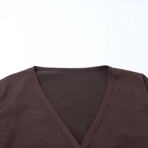 Detail of deep brown V-neck knit top showing the fine fabric texture and neckline finish