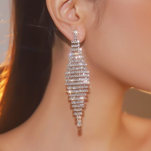 Macro detail of long silver fringe rhinestone earrings with sparkling geometric crystals