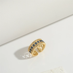 Gothic open ring in gold finish with hollow patterns and blue diamond-shaped stones