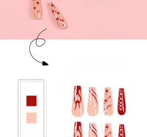 Macro detail of French long ballerina nails with flame patterns, hearts, and rhinestones