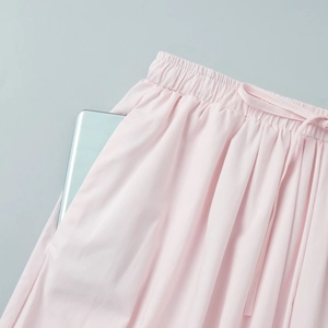 Close-up of pink cotton pants showing elastic waist and deep functional side pockets