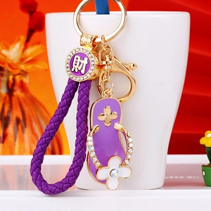 Detail of purple slipper keychain with sparkling rhinestones and a lucky Cai charm