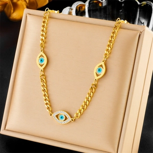 Gold-plated titanium steel necklace with blue evil eye pendants on beige velvet