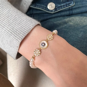 Bracelet perles eau douce plaqué or 18k avec œil grec et zircon porté au poignet