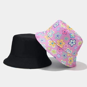Détail de bobs réversibles en noir uni et avec des motifs floraux colorés