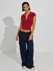 Detail of red slim-fit polo top paired with navy cargo pants for a sporty style