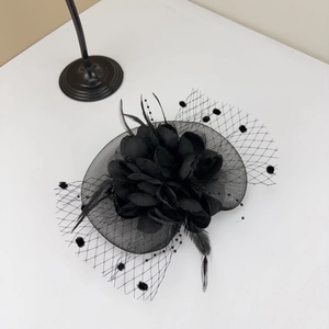 Detail of elegant black floral fascinator with vintage mesh veil and delicate feathers