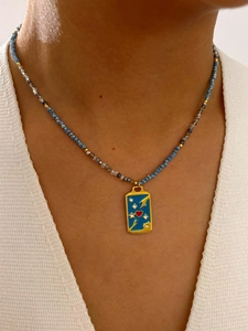 Gros plan d'un collier bohème en perles avec pendentif rectangulaire émaillé bleu