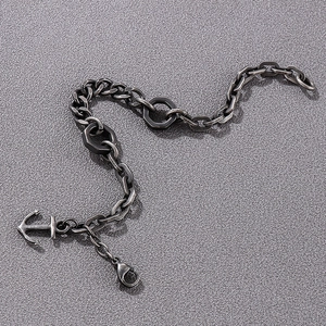 Close-up of vintage anchor pendant and hexagonal links on a dark silver chain bracelet