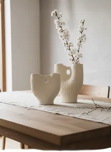 Détail de vases en céramique blanc mat avec texture martelée et centre creux moderne