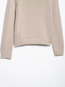 Détails des poignets et de l'ourlet côtelés sur cardigan beige en maille épaisse