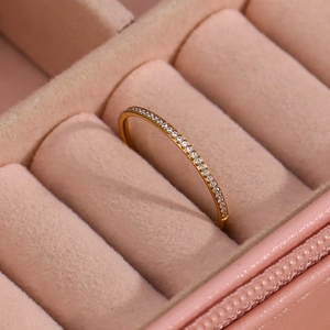 Macro shot of 18K gold plated thin ring with micro-set zircons on pink velvet