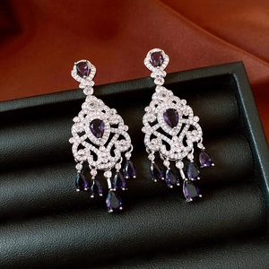 Detail of vintage silver tassel earrings with purple teardrop stones and white crystals