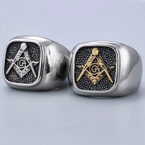 Detailed macro view of silver and gold plated Freemason rings with engraved G symbol