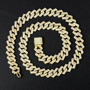Luxury gold cuban link necklace with white rhinestones on a textured black background