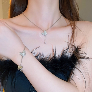 Detail view of elegant silver butterfly necklace and bracelet set worn by a model