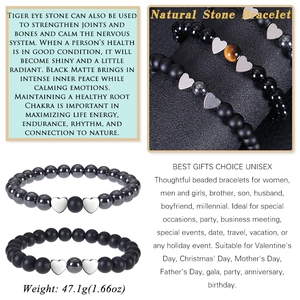 Macro shot of tiger eye beads and obsidian stones with a polished heart pendant