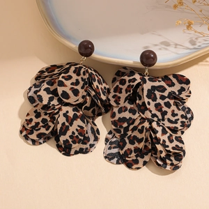 Close-up of leopard print fabric petal earrings with dark brown beads and gold metal links