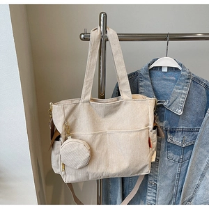Detailed texture of beige corduroy tote bag with mini round pouch accessory