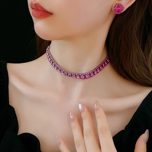 Close-up of pink crystal necklace and square stud earrings set worn by a model