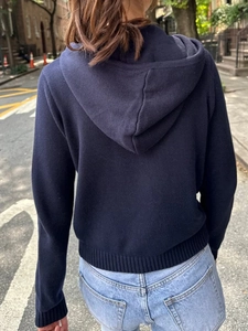 Détail de l'ourlet et des poignets en maille côtelée au dos d'un sweat à capuche bleu marine