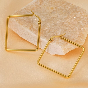 Polished gold square hoop earrings in titanium steel on an elegant textured backdrop