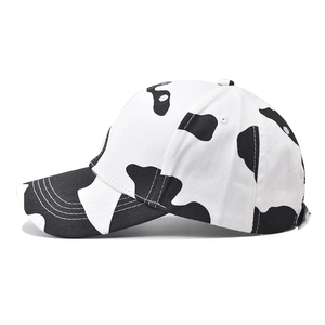 Classic cotton baseball cap with black and white cow print pattern on a white background