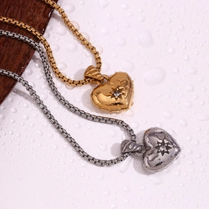 Detail of heart pendant necklaces in gold and silver with zircon on water drop background