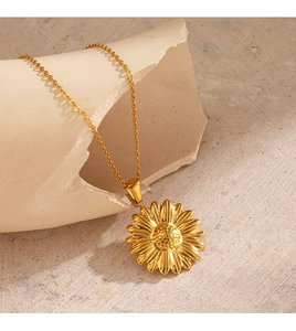 Detailed close-up of 18K gold-plated sunflower pendant on a textured minimalist background