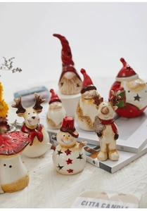 Close-up of ceramic Christmas figurines with star cutouts and festive hand-painted details