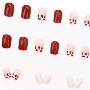 Short red and cow print press-on nails set in glossy finish for New Year festive style