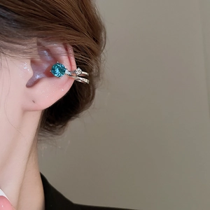 Gros plan d'une manchette d'oreille en argent avec cristal bleu et zircons au modèle