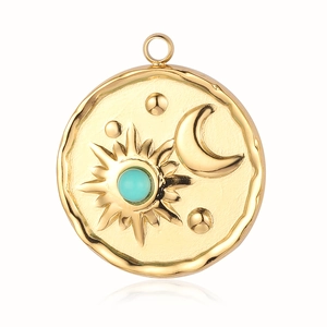 Detail of gold sun and moon pendant with embedded turquoise stone on white background