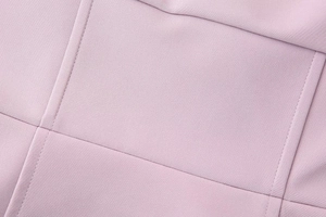 Close-up detail of light pink knitted fabric with clean stitching on a strapless dress