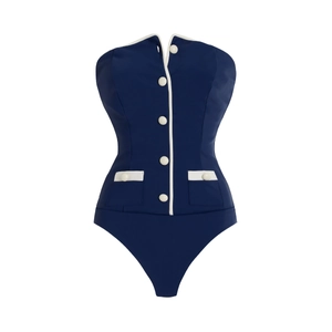 Detail of navy blue one-piece swimsuit featuring white buttons and nautical piping trim