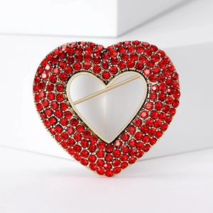 Elegant vintage gold heart brooch with red rhinestones on a clean white background