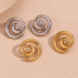 Detailed close-up of 18K gold and silver spiral earrings with inset cubic zirconia stones