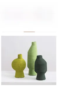Detalle de tres jarrones de cerámica con textura de rosca horizontal y tonos verde Morandi