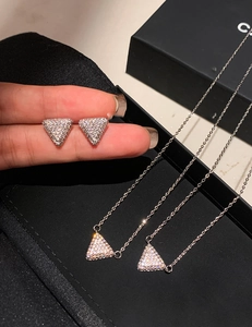 Detail of silver triangular earrings and necklace set with sparkling pave-set zircons