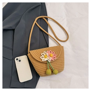 Detailed close-up of handmade straw bucket bag with floral accents and woven texture