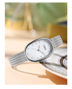 Macro detail of oval mother-of-pearl dial with diamond markers and silver mesh strap