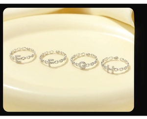 Macro detail of S925 sterling silver chain rings with hollow letters E F G H and zircon