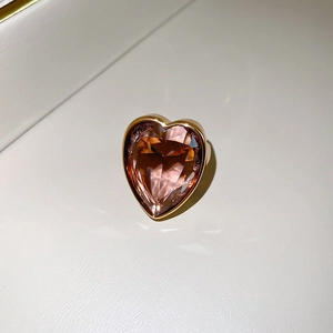 Close-up of heart-cut champagne zircon ring with polished gold bezel setting