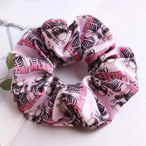 Close-up of pink oversized scrunchie with Valentine Club text and skull patterns